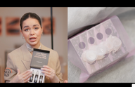 A woman holds a box with makeup products next to a display of lip gloss containers.