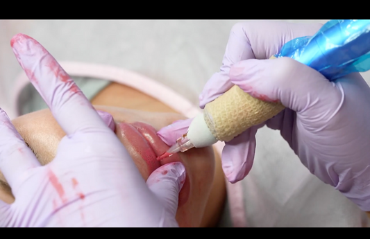 A hand with a gloved finger applies a treatment to a woman's lips.